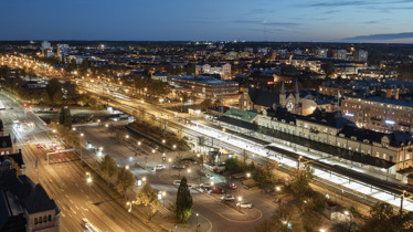 Silhuett av kraftledningar och ett vindkraftverk mot solnedgång