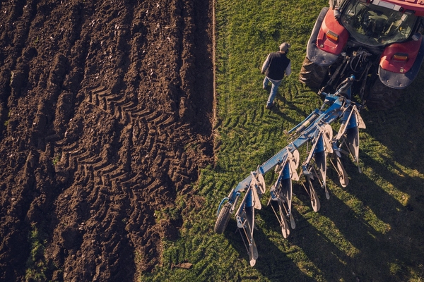 Luftvy av en bonde och en traktor som plöjer en mark. Foto: Scandinav Bildbyrå