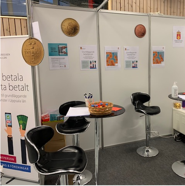 Mässmonter med informationsmaterial och svarta stolar