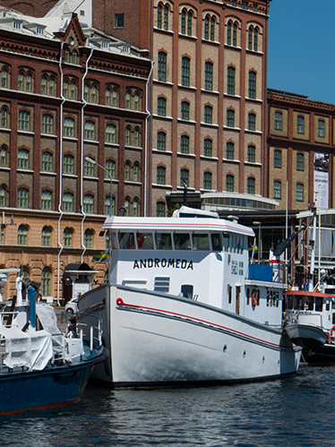 I förgrunden syns en vit båt som heter Andromeda, i bakgrunden syns Kalmar länsmuseum