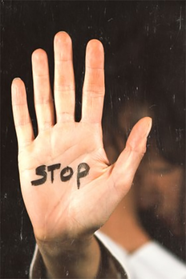 Närbild på en handflata med ordet STOP skrivet i svart tusch