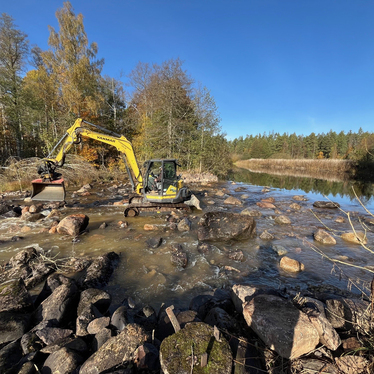 Grävmaskin i vattendrag som återställer strömsträcka