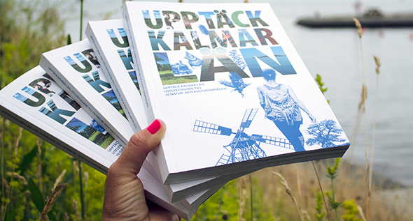 Hand som håller flera utflyktsguider