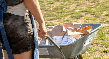 Person skjuter skottkärra framför sig