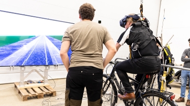 Krister Brus testar cykelsimulatorn instruerad av Lennart Ochel.. Foto: Katja Kircher/VTI