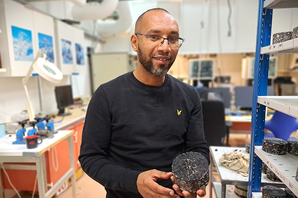 Abubeker Ahmed med ett prov på den klimatneutrala asfalten. Foto: Mikael Sönne / VTI.