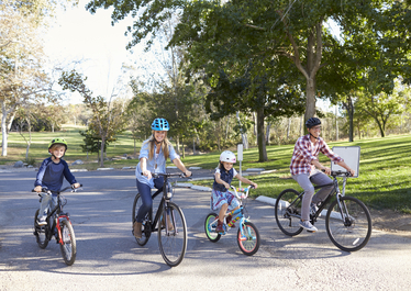 Familj som cyklar i solskenet. Foto: MonkeyBusiness/Mostphotos.com