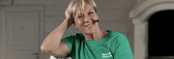 Sofia sitter på en stol med ett headset i träningströja. 