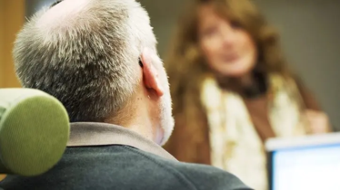 Ett samtal mellan man och kvinna, man ser mannen bakifrån.