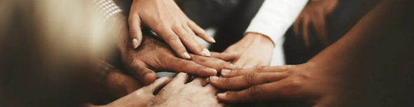 Bild på händer och fingrar som hålls mot varandra i en mitt. 