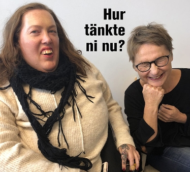 Karolina Celinska till vänster i vit tröja och svart sjal tittar in i kameran och skrattar. Janna Olzon sitter till högermed svart tröja och glasögon, skrattar stort med stängda ögon.