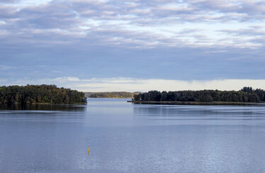 Stilla sjö med öar och molnig himmel