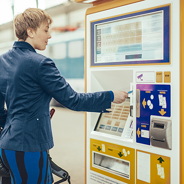 A person using a ticket machine. Photo.