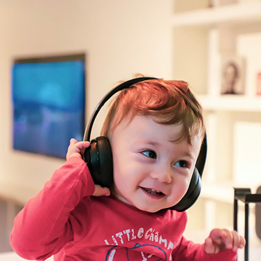 A baby listening to headphones. Photo.