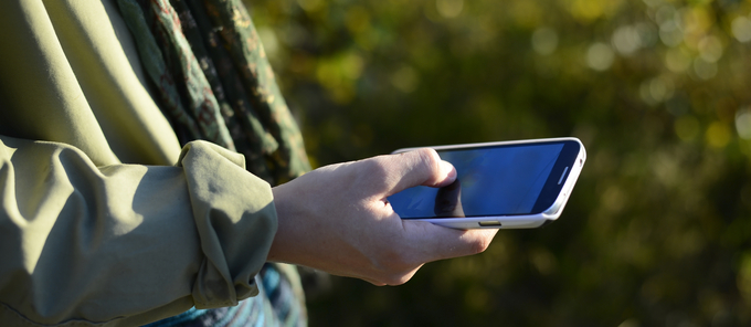 Person håller en smartphone utomhus