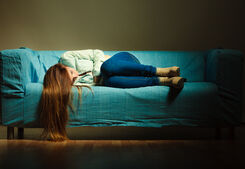 Kvinna som ligger i soffa.