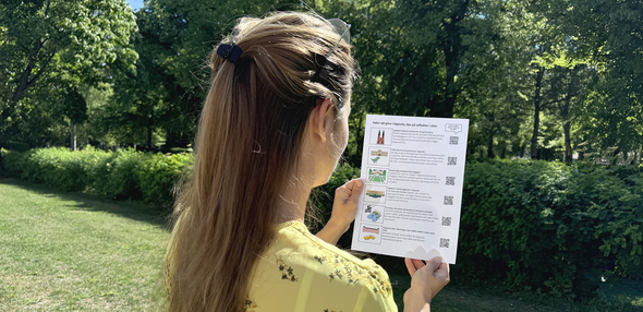 Person i park tittar på en bildkarta med tips på platser att besöka.