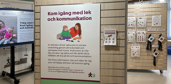 Utställningsmiljön i förgrunden stor affisch "Kom igång med lek och kommunikation".