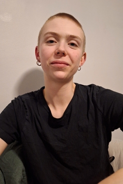 Porträttbild på Elias, med snaggat hår och svart t-shirt.