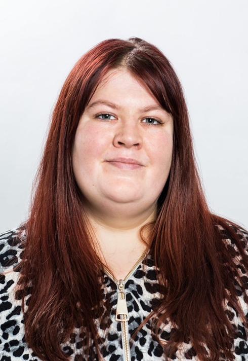 Therese Wappsell med rött hår och djurmönstrad jacka ler mot kameran.