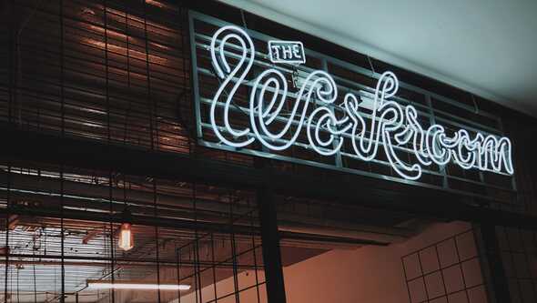 Neonskylt med texten The Workroom.