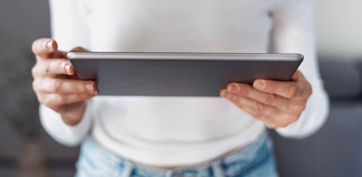 Person som håller en surfplatta med båda händerna.