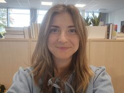 Leende kvinna med långt brunt hår.