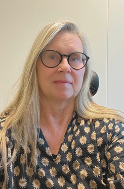 Porträtt av en kvinna med långt ljust hår och glasögon.