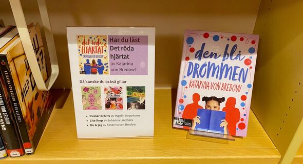 En skylt med texten Har du läst Det röda hjärtat av Katarina von Bredow då kanske du också gillar - med  tre boktips. Boken Den blå drömmen av Katarina von Bredow står skyltad bredvid.