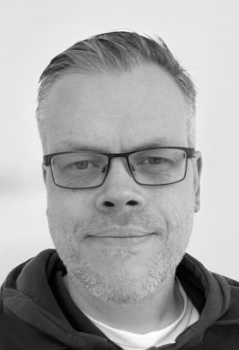 Porträtt av en person med glasögon i svartvitt.