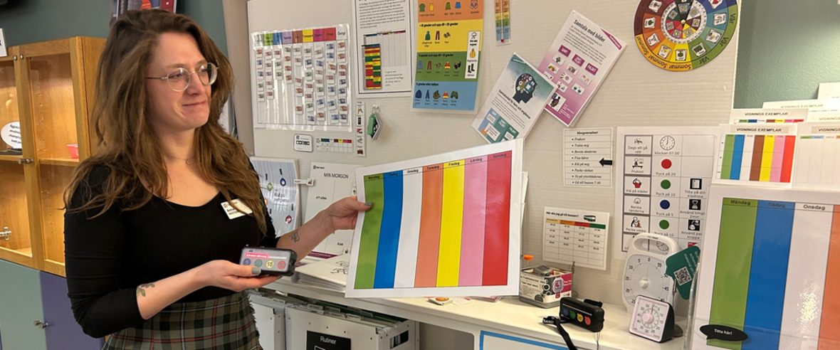 Kvinna visar veckoschema i en pedagogisk miljö.