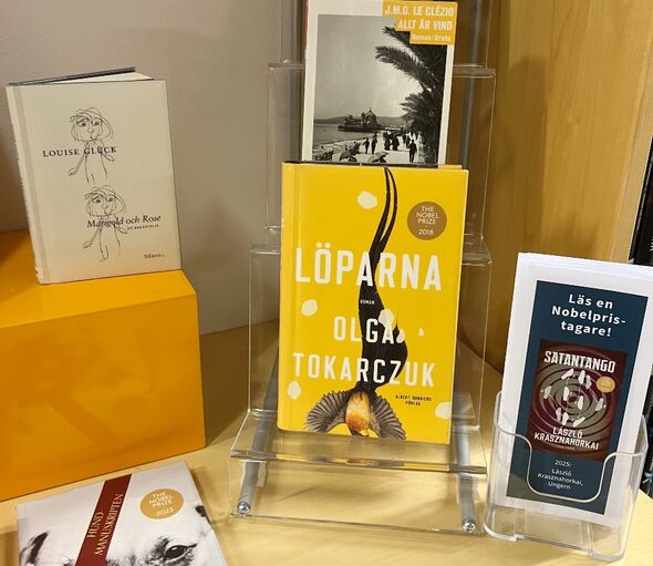 Bokskyltning med bland annat boken Löparna av Olga Tokarczuk bredvid en boktipsfolder.