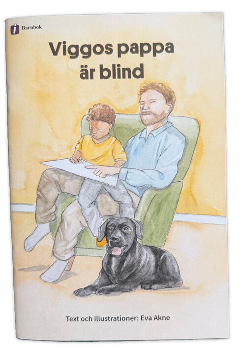 Omslag på boken "Viggos pappa är blind" som visar en man och ett barn som sitter i en fåtölj med en hund framför dem.