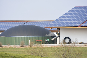 Lantgård med solpaneler på taket och en biogasanläggning.