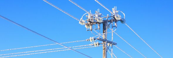 Frostig elledning mot blå himmel. 