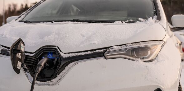 Elbil som laddas med snö på motorhuven.