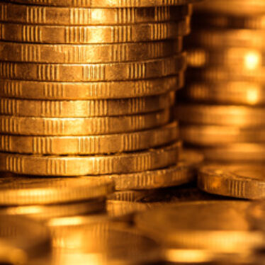 Närbild av staplade gyllene mynt.